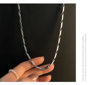 Close-up of geometric silver link chain necklace with polished metallic finish