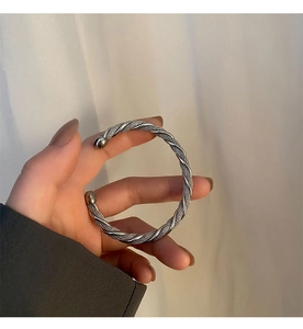 Detail view of silver stainless steel twisted cable cuff bracelet with beaded ends