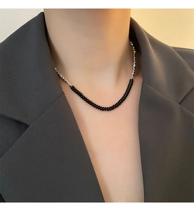 Dettaglio della collana girocollo con perle nere tonde e accenti in metallo argento