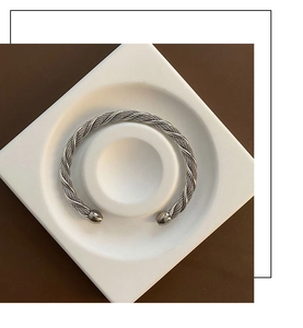 Detailed view of the silver twisted cable bangle showing intricate woven metal texture