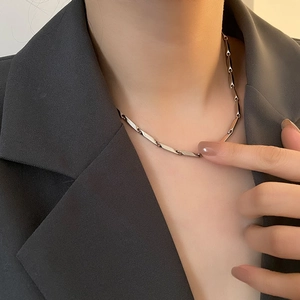 Minimalist silver titanium steel necklace with twisted rectangular links on a model