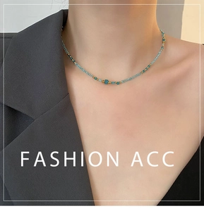 Détail d'un collier en pierre naturelle bleue fait main sur une femme en blazer gris