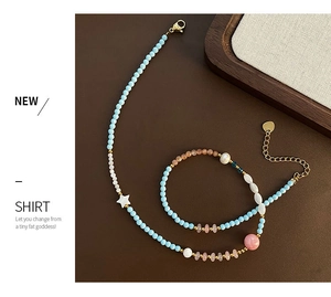 Detail of beaded necklace with light blue stones, pink beads, and shell stars