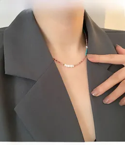 Detailed view of colorful beaded necklace with pearls on a model wearing a blazer
