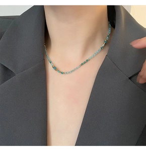 Détail du collier de perles en pierres naturelles bleues et perles dorées sur le cou