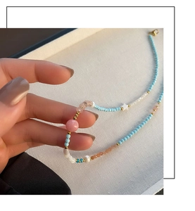 Close-up of star and strawberry crystal beaded necklace with gold accents and pearls