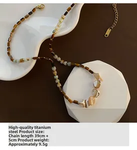 Detail view of handmade titanium steel necklace with tiger eye stone and shell beads