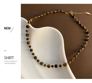 Macro detail of brown tiger eye beaded necklace with adjustable gold clasp and extension