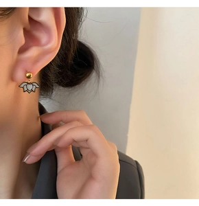 Detail of elegant gold lotus earrings on a model showing modern minimalist style