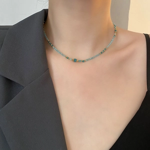 Collier élégant en perles dorées et bleu ciel avec pierre turquoise sur un mannequin