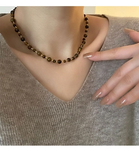 Detailed close-up of tiger eye beads and gold spacers on a retro handmade necklace