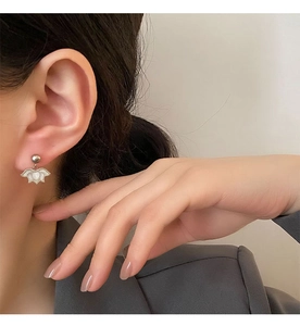 Close-up of minimalist silver lotus petal earrings worn by a model for a chic look