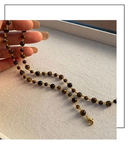 Detailed view of handmade tiger eye beaded necklace with gold spacer beads and lobster clasp