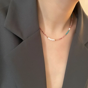 Beaded natural stone necklace with freshwater pearls and gold accents on a model