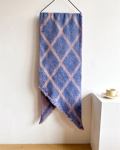 Détail d'une écharpe à carreaux bleus et roses avec texture douce et franges