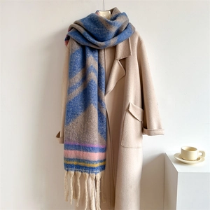 Thick beige winter coat paired with a long colorful striped tassel cashmere-like scarf