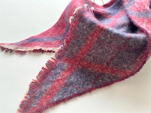 Vue détaillée d'une écharpe bouclée à carreaux rouge et violet avec franges