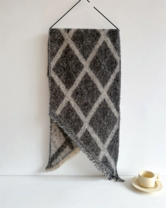 Détail d'écharpe en maille bouclée à carreaux gris et blancs avec bordure à franges