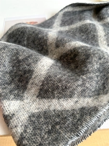 Détail d'une écharpe en tricot à carreaux gris et blancs avec texture brossée douce