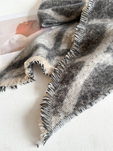 Détail d'écharpe à carreaux gris et beige avec bords à franges et texture laineuse