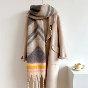 Detailed texture of thick geometric color-block scarf with fringes on beige coat