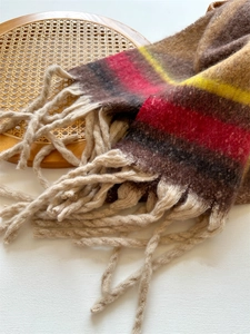 Close-up of thick striped knit scarf showing fuzzy texture and twisted fringe detail