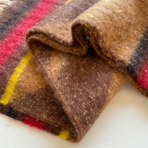 Close-up of thick striped boucle scarf showing soft fuzzy texture and vibrant fringes