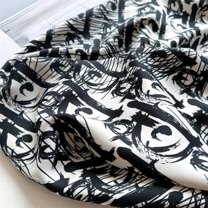 Detailed view of luxury silk scarf with black and white abstract ink pattern and soft texture