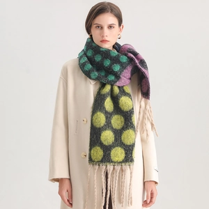 Detail of soft thick scarf with large colorful polka dots and fringe tassels decoration