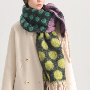Detail of colorful polka dot knit scarf with soft tassels and cozy thick texture