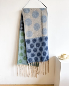 Detail of colorful polka dot knit scarf with tassels hanging on a wall hanger