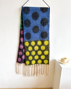 Detail of colorful polka dot knit scarf with long cream tassels and thick texture