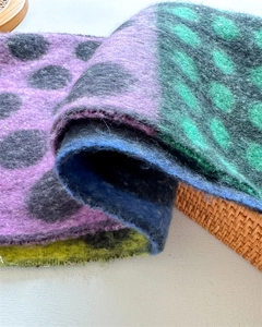 Close-up of soft faux wool scarf featuring colorful color blocks and dark polka dot patterns
