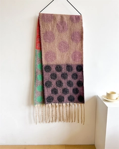 Close-up of thick multi-color polka dot scarf with long fringe tassels and wool-like texture