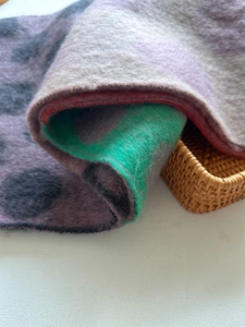 Detail of soft thick scarf featuring colorful patchwork panels and dark polka dot patterns
