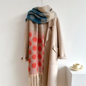 Detailed close-up of thick winter scarf with colorful polka dots and fringe accents