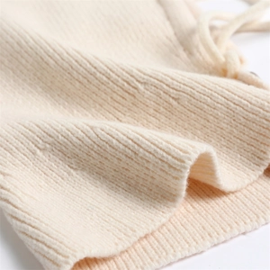 Detailed macro view of the cream ribbed knit texture and cylindrical drawstring finish