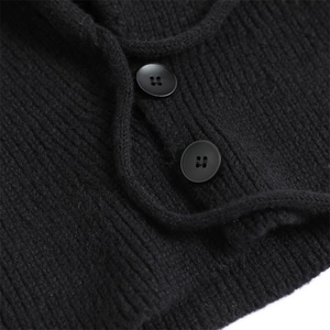 Macro detail of black ribbed knit fabric with matte four-hole buttons on balaclava