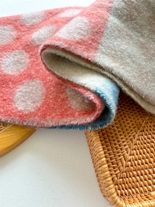 Close-up of thick wool-like scarf with colorful polka dots and soft plush texture