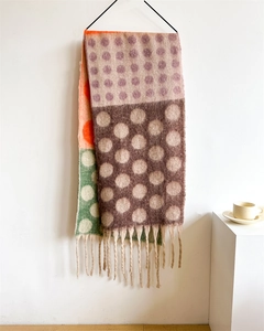 Detail of soft multi-color knit scarf with polka dots and cream fringe tassels