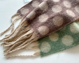 Detail of retro polka dot wool-like scarves with soft texture and long fringe edges