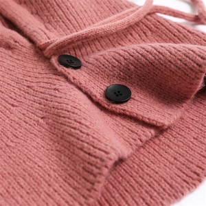 Detail of pink knitted balaclava showing ribbed texture and black button accents