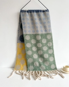 Detail of soft faux cashmere scarf with colorful oversized polka dots and fringe trim