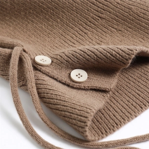 Close-up of brown ribbed knit texture with ivory buttons and adjustable drawstring detail