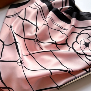 Macro detail of pink silk scarf with diamond lattice and elegant camellia patterns