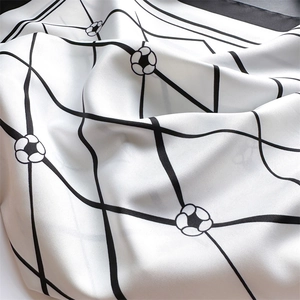 Detailed view of silk texture with elegant diamond grid and floral pattern on square scarf