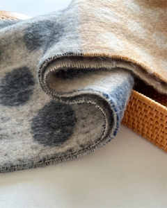 Detailed close-up of thick knitted scarf showing soft wool texture and polka dot pattern