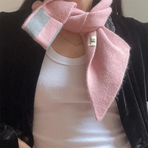 Close-up of pink knitted scarf with grey contrast stripe and soft wool-like texture