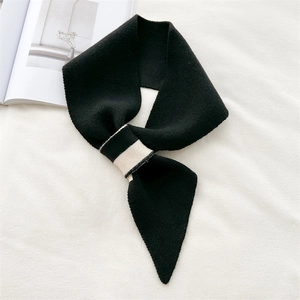Detailed view of the black knitted scarf showing texture and unique cross-buckle closure