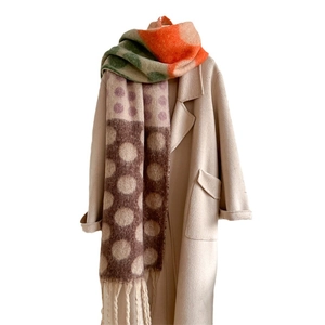 Retro thick wool-blend scarf with colorful polka dots and tassels over a beige coat
